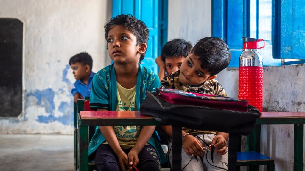 pexels-photo-18012462 Joyful Indian children sitting in a colorful classroom, engaged and curious.